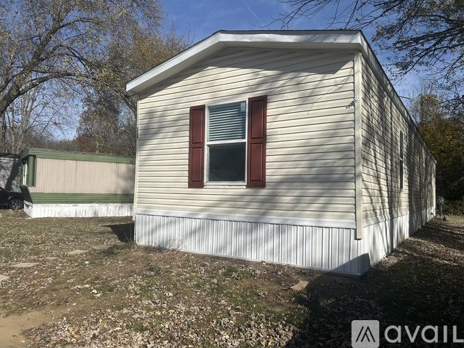 A small house with a red window is for sale.