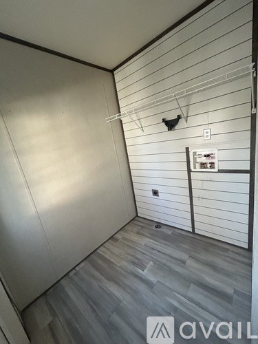 A small, empty room with a grey floor and white walls.