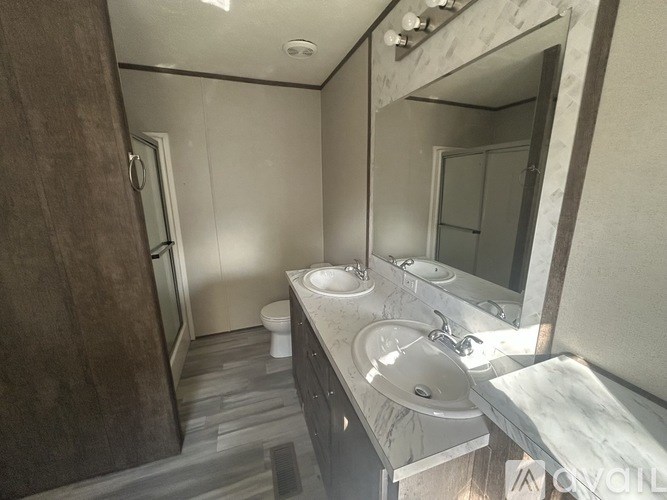 A bathroom with a toilet, sink, and mirror.