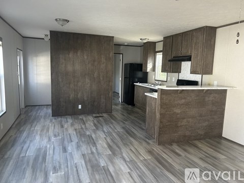 A kitchen with wooden cabinets and a refrigerator.