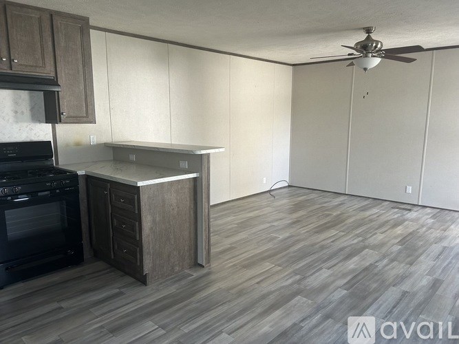A kitchen with a black oven and wooden cabinets.