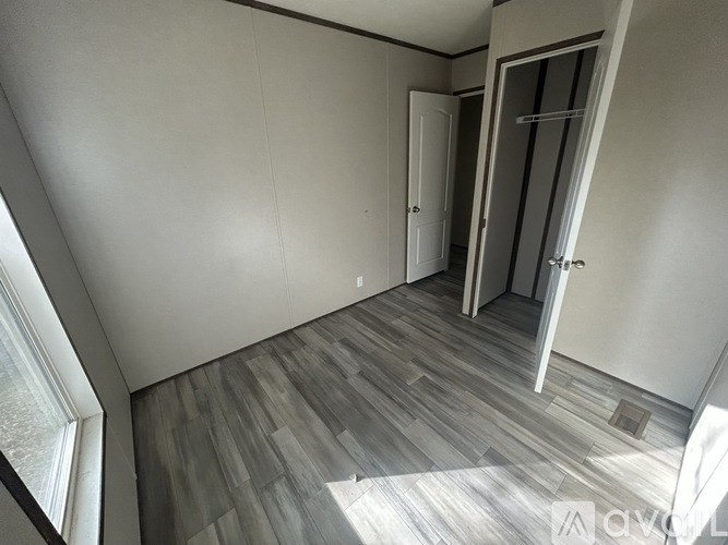 A room with a wooden floor and white walls.