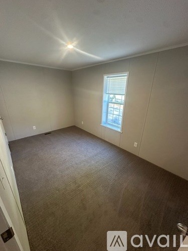 A room with a carpeted floor and a window.