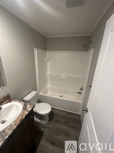 A bathroom with a toilet, sink, and bathtub.