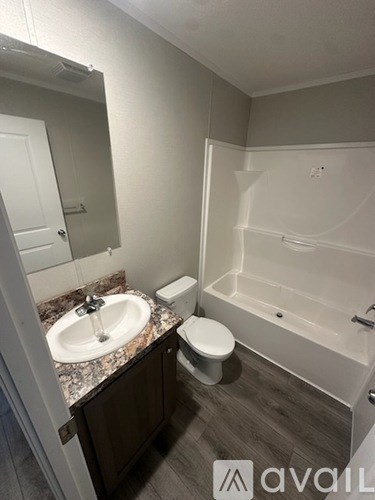 A bathroom with a sink, toilet, and bathtub.