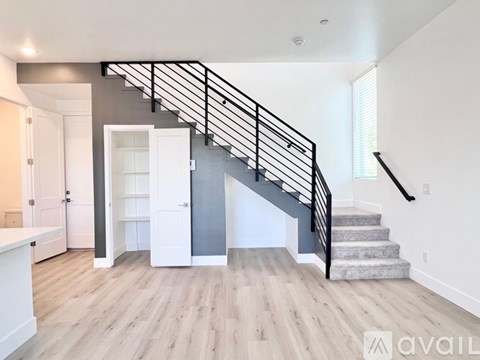 A spacious living room with a staircase leading to the upper floor.