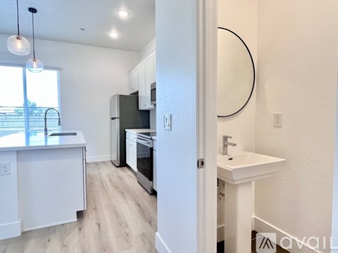 A kitchen with white cabinets and a black fridge.