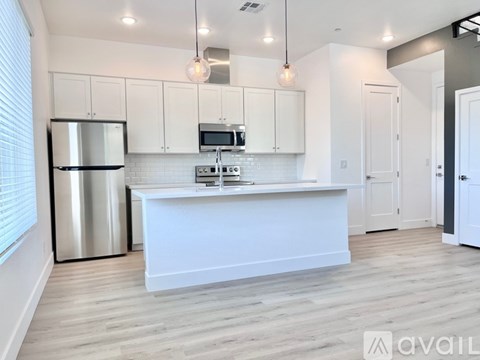 A kitchen with white cabinets and a stainless steel refrigerator.