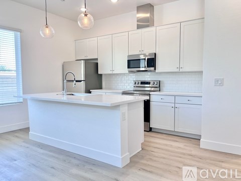 A kitchen with white cabinets and a black dishwasher.