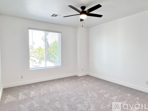 A room with a ceiling fan and a window.