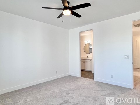 A room with a ceiling fan and a carpeted floor.