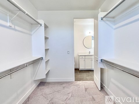 A white hallway with a carpeted floor and a white cabinet.