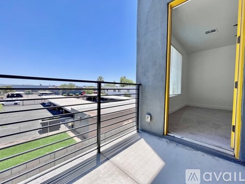 A balcony with a yellow door and a black railing.