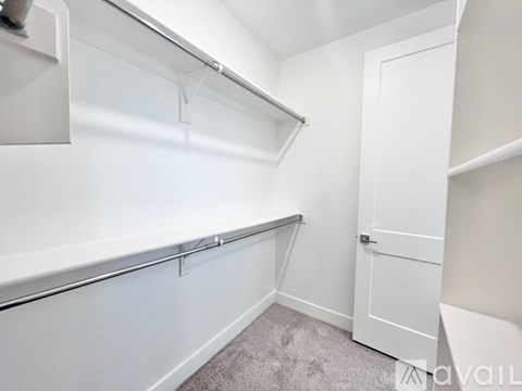 A small, empty room with a door and a shelf.