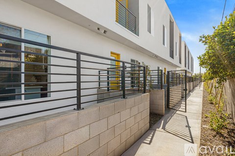 A modern building with a white facade and black railings.
