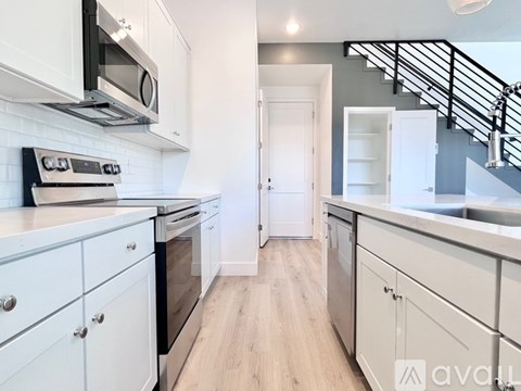 A kitchen with white cabinets and a stove top oven.