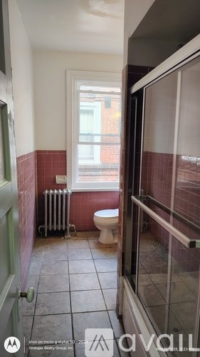A bathroom with a toilet and a window.