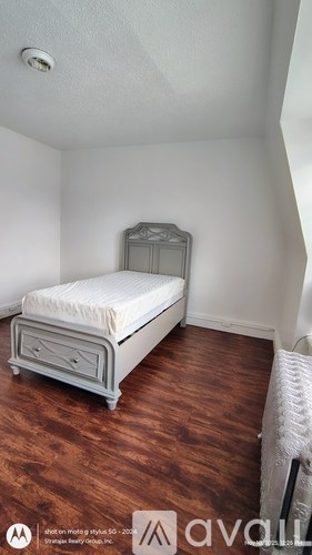 A bedroom with a bed, dresser and mirror.
