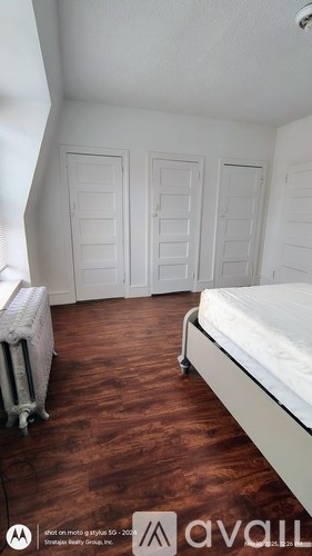 A bedroom with a bed, a chair, and a wardrobe.