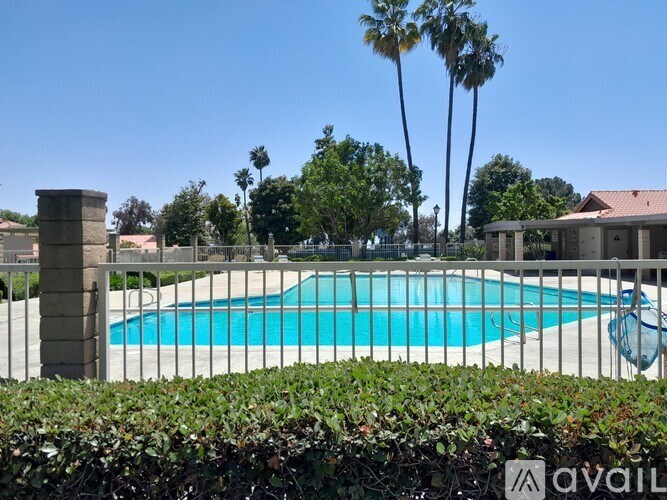 A pool surrounded by a fence and trees.