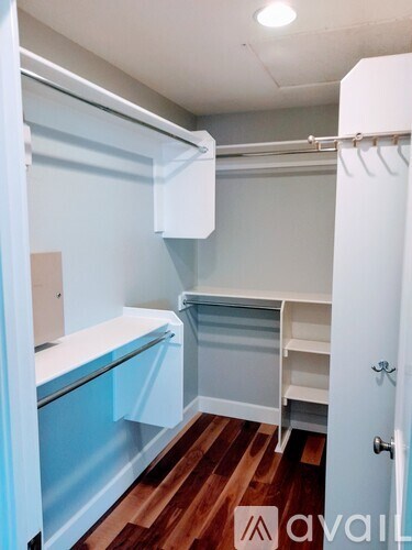 A white and blue kitchen with wood floors.