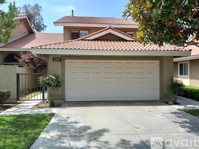 A house with a garage and a driveway in front of it.