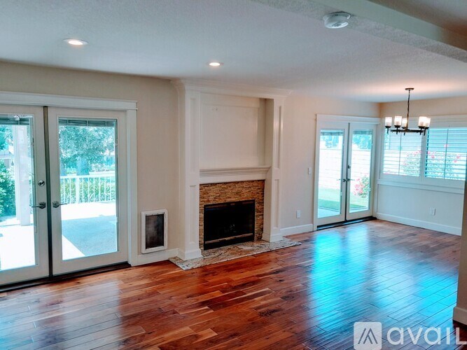 A living room with a fireplace and wood flooring.