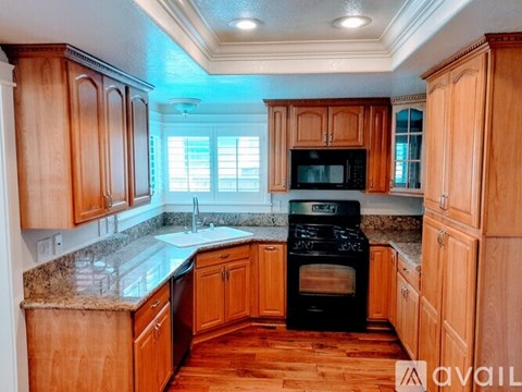 A kitchen with wooden cabinets and a black oven.