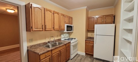A kitchen with wooden cabinets and a white refrigerator.