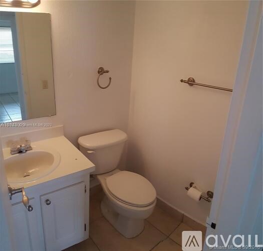 A white toilet and sink in a small bathroom.