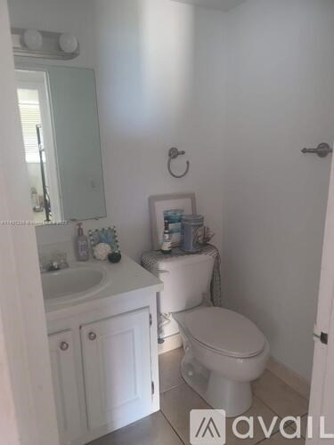 A white toilet sits next to a sink in a small bathroom.