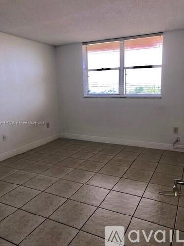 A room with a tiled floor and a window letting in light.