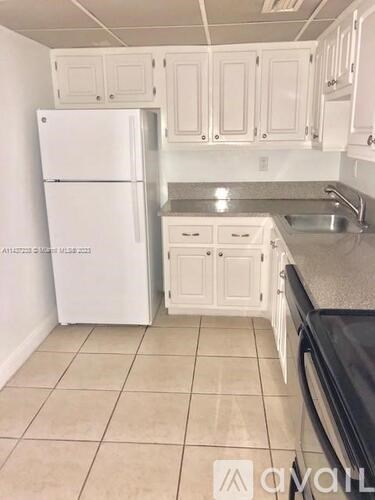 A kitchen with white appliances and cabinets.