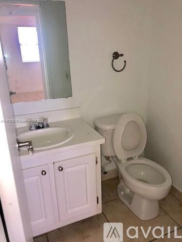 A white bathroom with a toilet, sink, and medicine cabinet.