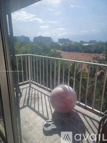 A balcony with a ball on it and a view of the city.