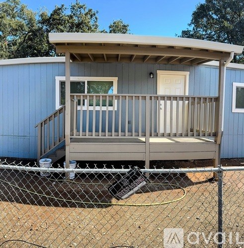A small house with a porch and a fence.