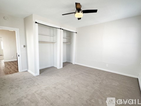 A room with a ceiling fan and a carpeted floor.