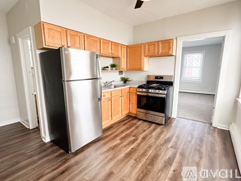 A kitchen with a refrigerator, oven, and stove.