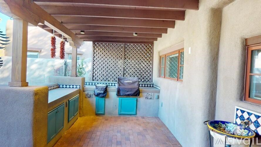 A patio with a blue and white tiled wall and a wooden ceiling.