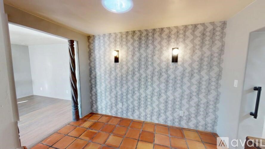 A room with a tiled floor and patterned wallpaper.