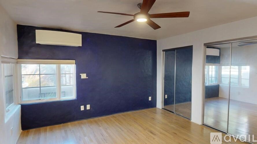 A room with a ceiling fan and a window.