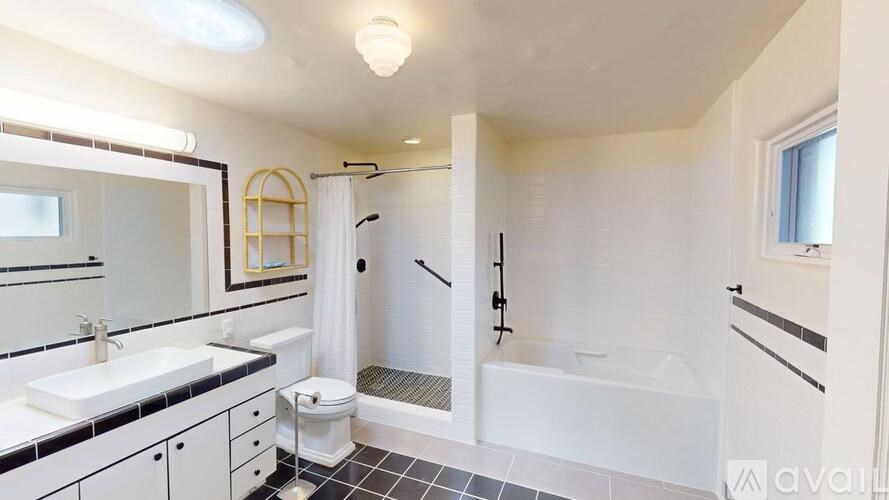 A bathroom with a white tub, sink, and toilet.