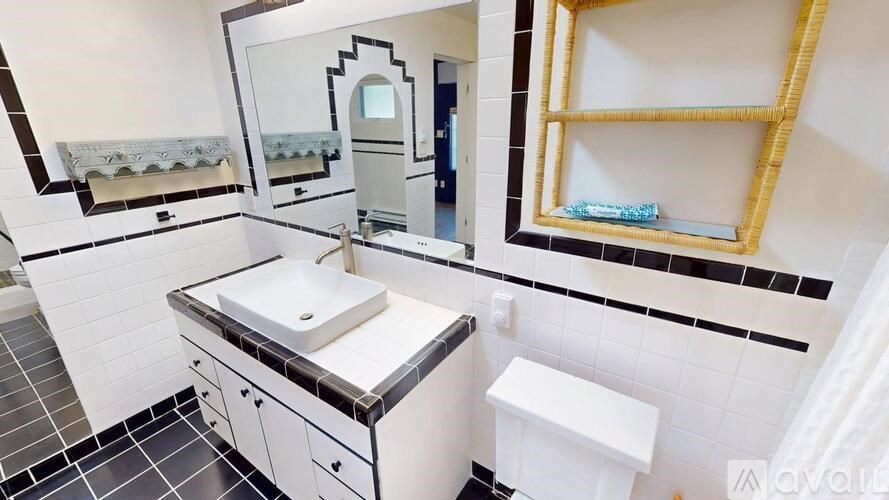 A bathroom with a sink, mirror, and toilet.