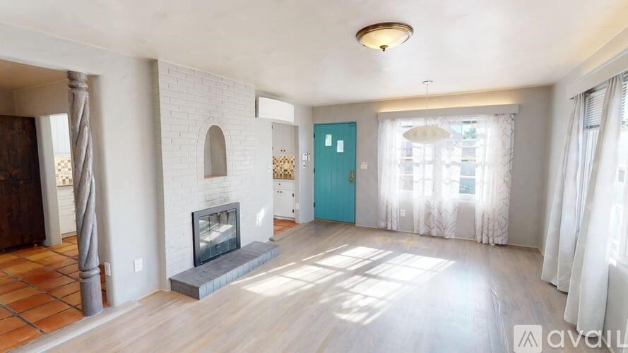 A living room with a fireplace and a blue door.