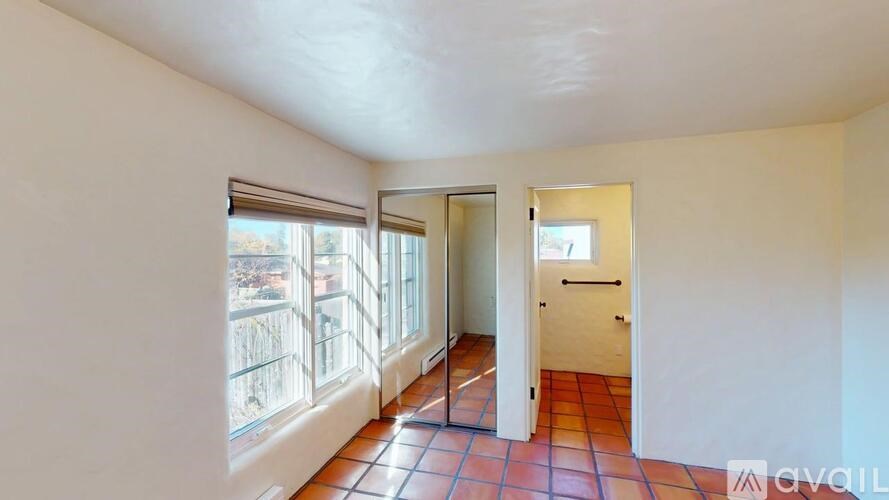A room with a tiled floor and a door leading to another room.