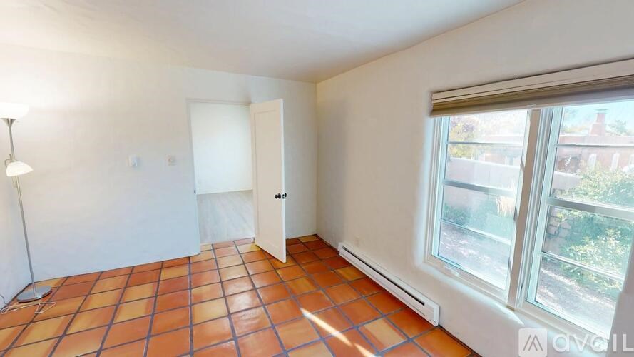 A room with a tiled floor and a window overlooking a street.