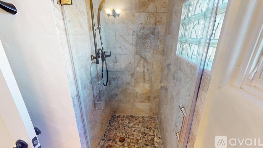 A bathroom with a shower and a tiled floor.
