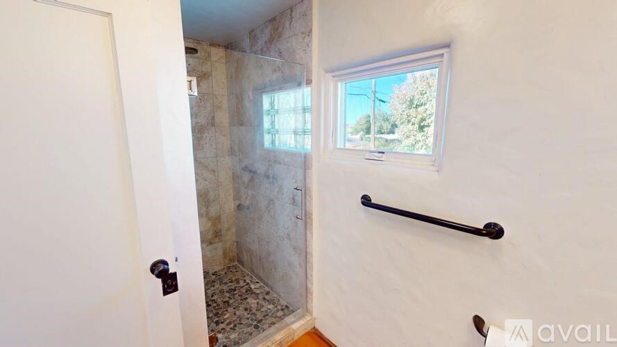 A bathroom with a shower and a window.