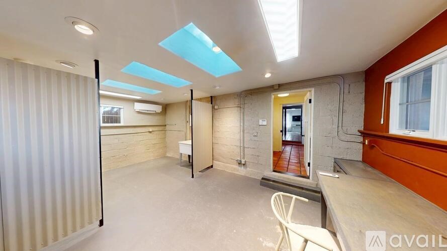 A room with a white chair and a table in it.