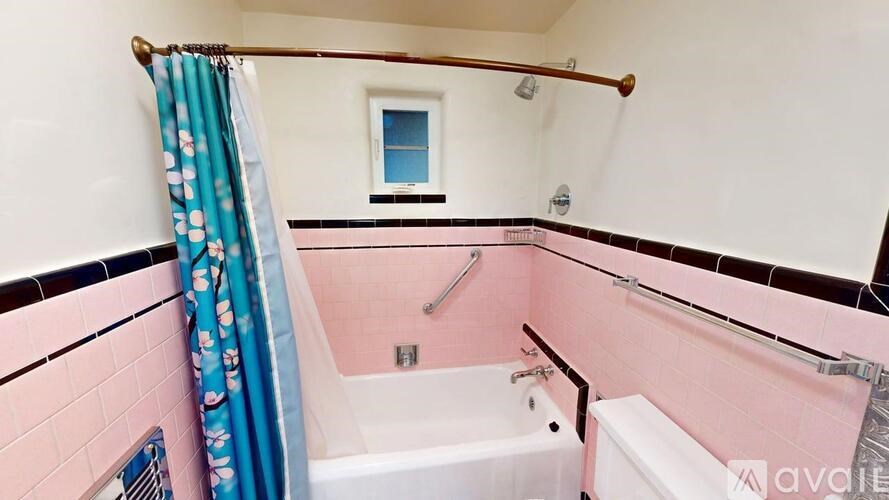 A bathroom with pink walls and a white bathtub.